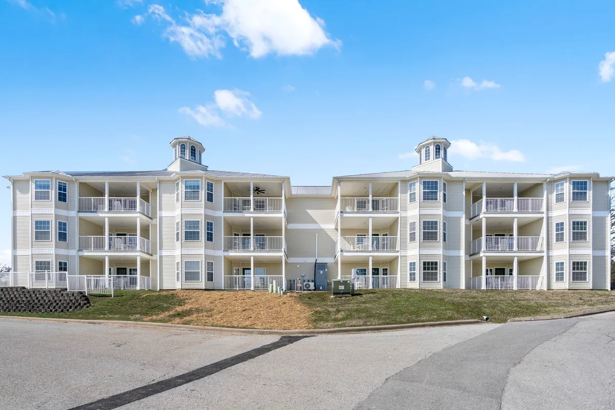 An inviting exterior shot of the resort building, with architectural details, balconies, and a cupola. Surrounding the building are landscaped lawns and paved walkways, ideal for casual strolls and outdoor gatherings.